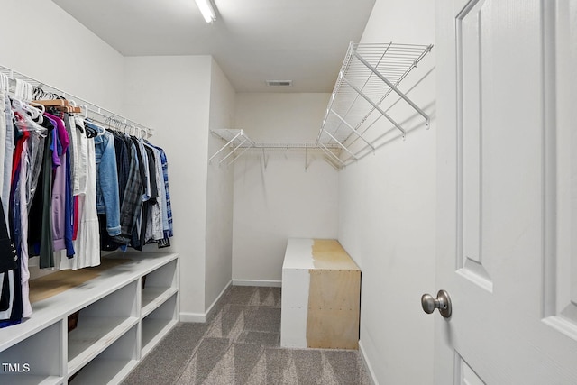 walk in closet featuring dark carpet and visible vents