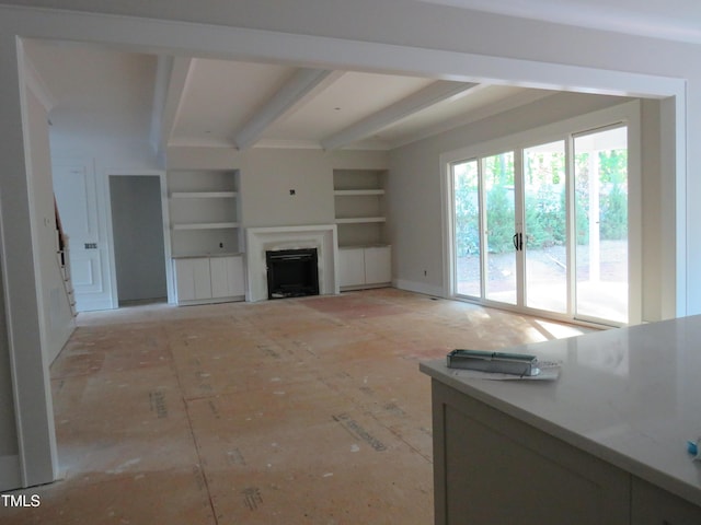 living area featuring built in shelves, beam ceiling, and a fireplace