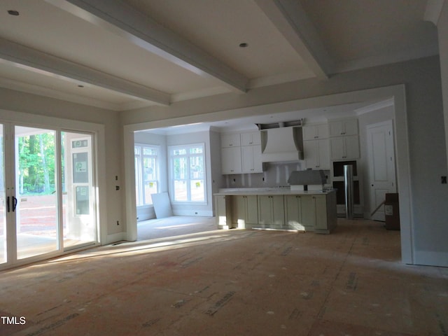 unfurnished living room featuring plenty of natural light and beam ceiling