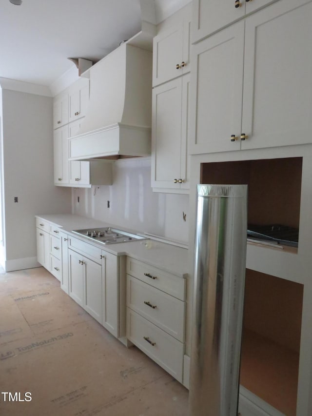 kitchen featuring light countertops, electric stovetop, premium range hood, and white cabinets
