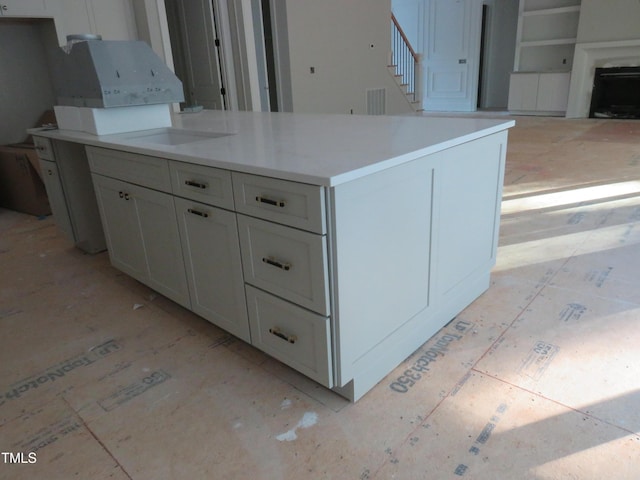 kitchen featuring light countertops, white cabinets, and open floor plan