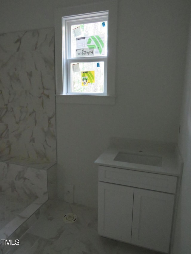 bathroom with vanity, marble finish floor, and a shower