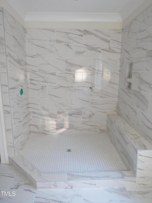 full bath with crown molding, a tile shower, and marble finish floor
