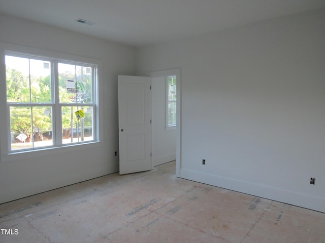 unfurnished room with baseboards, plenty of natural light, and visible vents