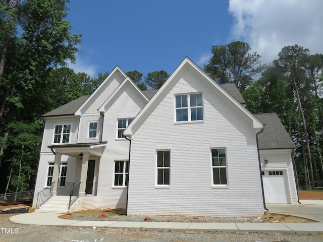 1444 Old Apex Rd, Cary, NC 27513 - view of front of property featuring a garage, driveway, brick siding, board and batten siding, and a shingled roof
