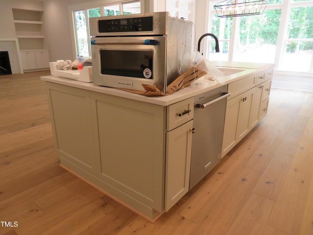 1444 Old Apex Rd, Cary, NC 27513 - kitchen with a sink, appliances with stainless steel finishes, light wood-style flooring, and a kitchen island with sink