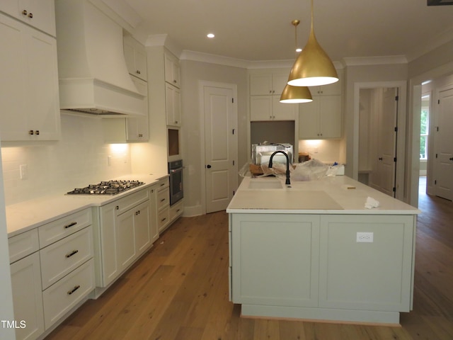 1444 Old Apex Rd, Cary, NC 27513 - kitchen with premium range hood, wall oven, stainless steel gas cooktop, a sink, and wood finished floors