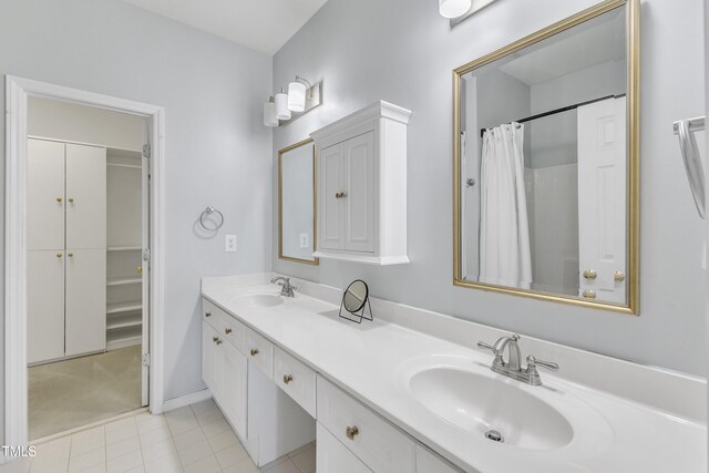 bathroom featuring double vanity, tile patterned flooring, baseboards, and curtained shower