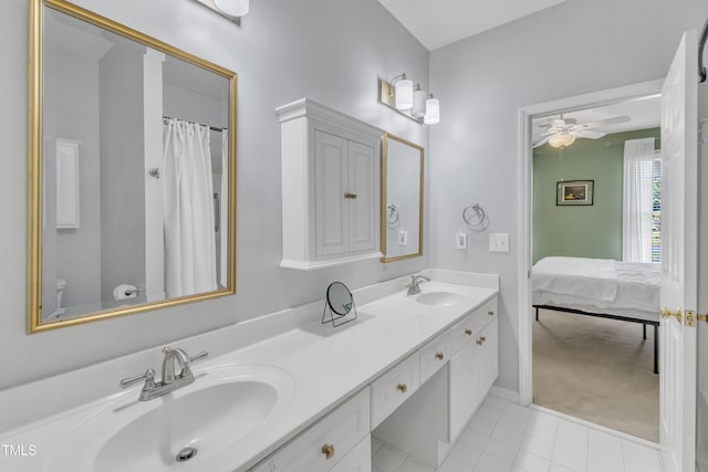 ensuite bathroom featuring double vanity, ceiling fan, tile patterned flooring, and baseboards