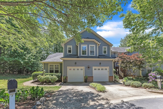 traditional home featuring an attached garage, driveway, and brick siding