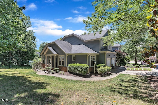 view of front of home featuring a front lawn, a shingled roof, a garage, and brick siding
