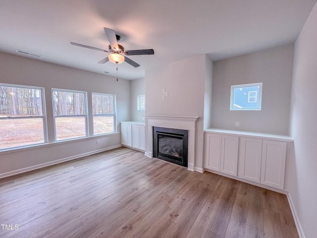 355 Beacon Hill Rd # 23, Lillington, NC 27546 - unfurnished living room with light wood-type flooring, a ceiling fan, and a glass covered fireplace