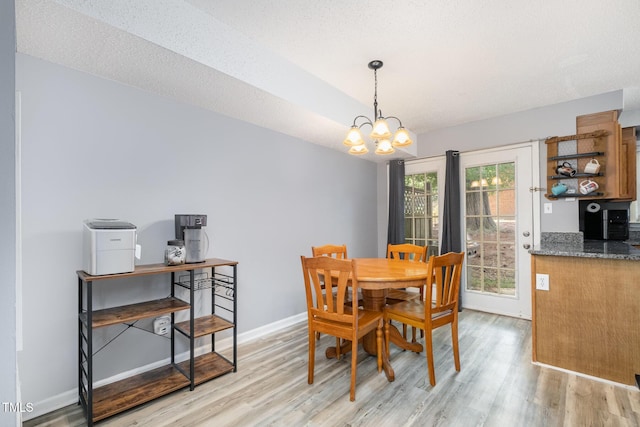 dining area featuring baseboards, an inviting chandelier, and light wood finished floors