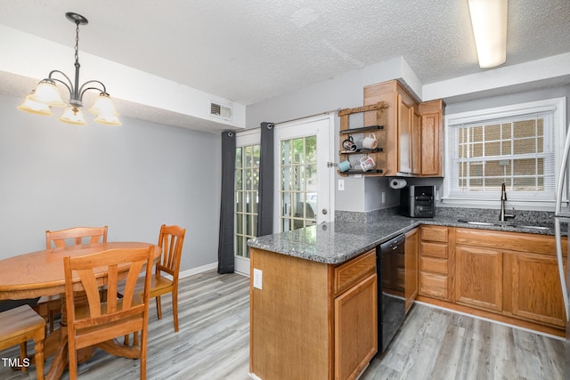 kitchen with dishwasher, a sink, a peninsula, light wood finished floors, and an inviting chandelier