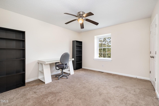 unfurnished office with carpet flooring, ceiling fan, and baseboards