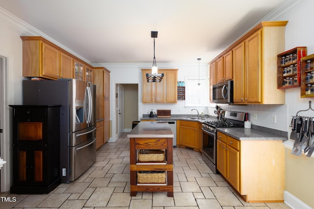 kitchen featuring stainless steel appliances, a sink, tasteful backsplash, dark countertops, and hanging light fixtures