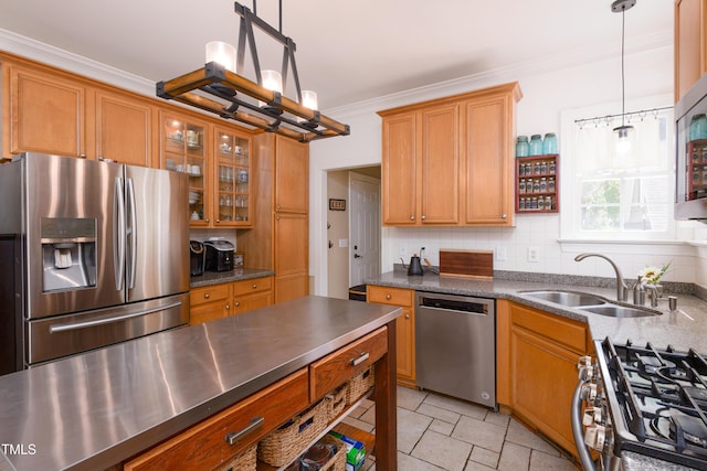 kitchen with appliances with stainless steel finishes, crown molding, a sink, and brown cabinets