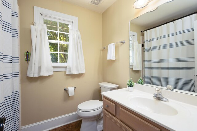 bathroom with baseboards, toilet, vanity, and a shower with shower curtain
