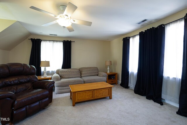 living area with light carpet, a ceiling fan, and baseboards