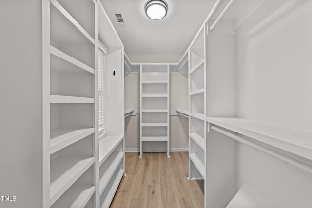 walk in closet with light wood-style floors