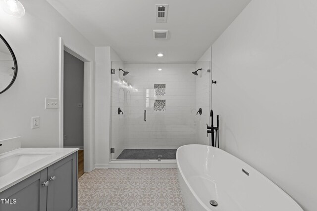 full bathroom featuring a stall shower, a soaking tub, vanity, and recessed lighting