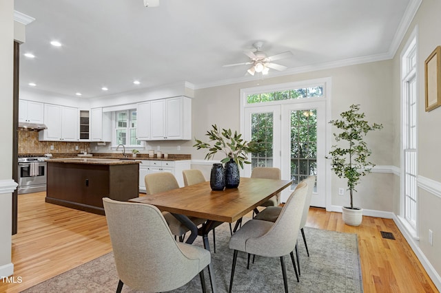 dining space with plenty of natural light, a ceiling fan, light wood-type flooring, recessed lighting, and crown molding