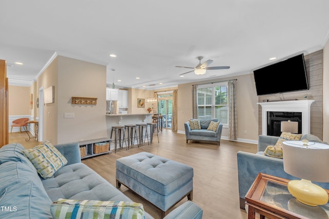 1920 Bright Kannon Way, Wendell, NC 27591 - living area featuring crown molding, ceiling fan, recessed lighting, light wood-style floors, and a glass covered fireplace