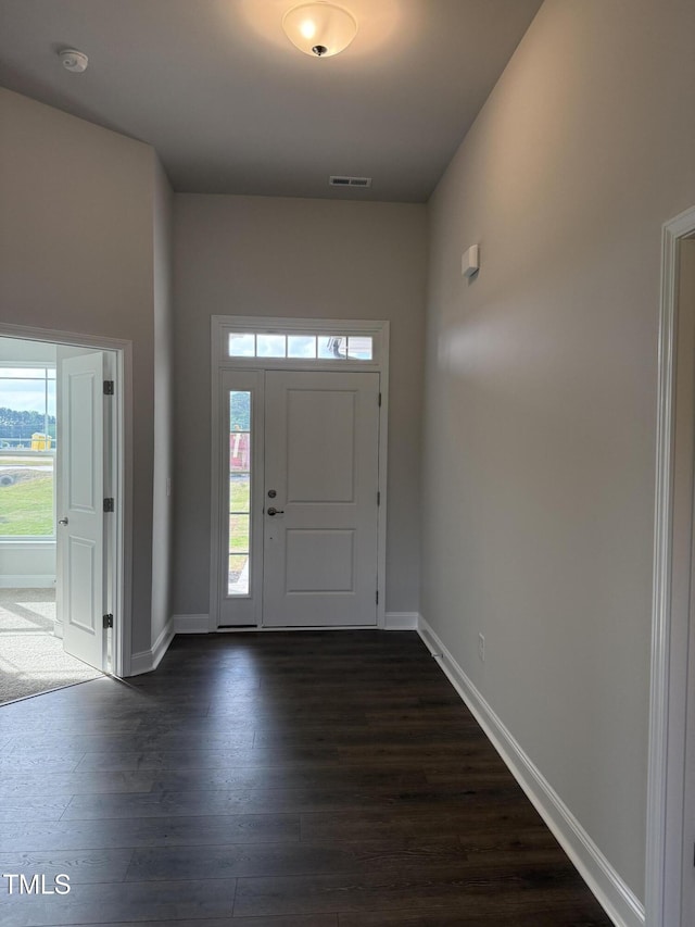 entrance foyer with visible vents, baseboards, and dark wood-type flooring