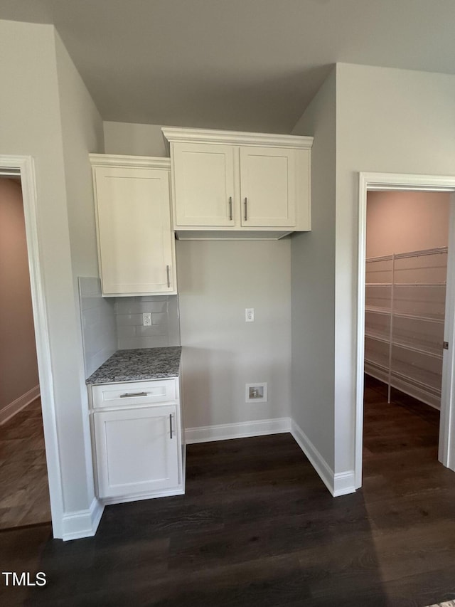 kitchen featuring decorative backsplash, light stone countertops, baseboards, dark wood-style floors, and white cabinets