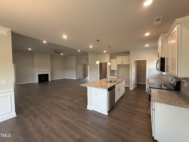 kitchen featuring appliances with stainless steel finishes, a sink, a fireplace, open floor plan, and visible vents
