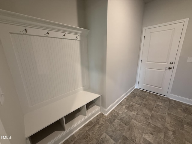 mudroom with baseboards and stone finish floor