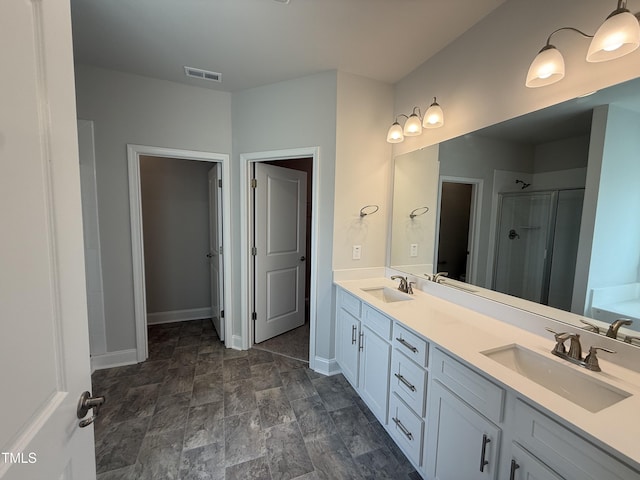 bathroom with visible vents, a sink, double vanity, and a shower stall