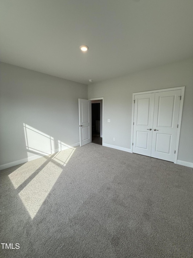 unfurnished bedroom featuring recessed lighting, baseboards, carpet, and a closet