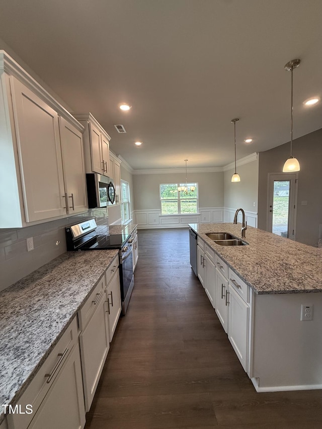 kitchen with dark wood-style flooring, visible vents, a sink, ornamental molding, and stainless steel appliances