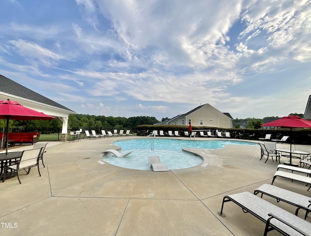 community pool featuring a patio and fence