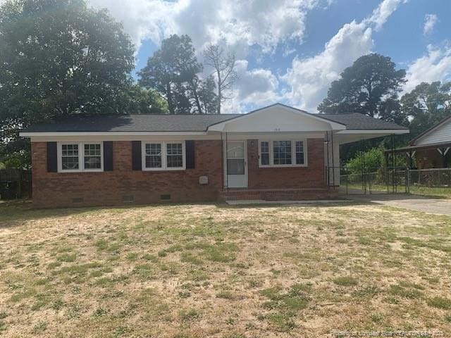 ranch-style home featuring crawl space, a front yard, a carport, brick siding, and concrete driveway