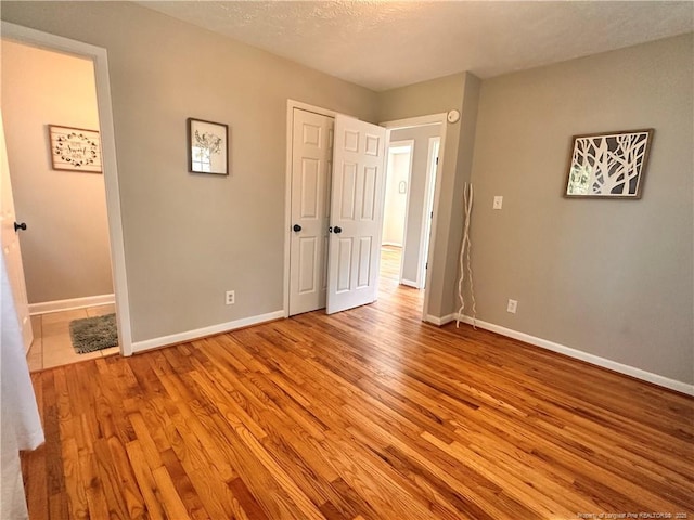 unfurnished bedroom with baseboards and wood finished floors