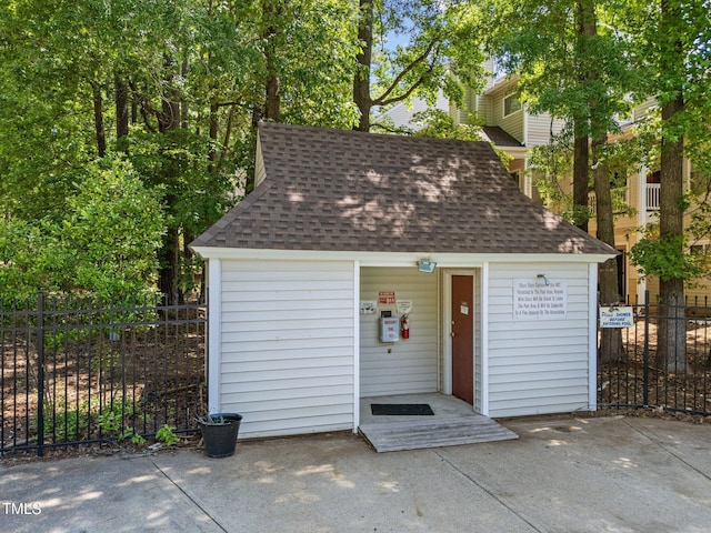 view of outdoor structure featuring fence and an outbuilding