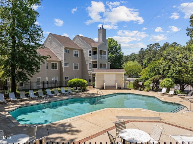 community pool featuring fence and a patio area