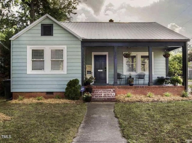 200 S Pettigrew St, Raleigh, NC 27610 - bungalow featuring a porch, metal roof, crawl space, and a front lawn
