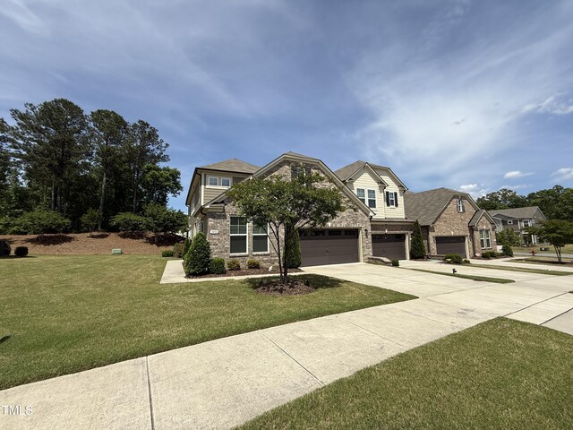 view of front of home featuring stone siding, concrete driveway, a front yard, and an attached garage