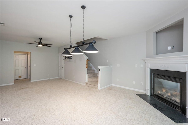 7616 Satinwing Ln, Raleigh, NC 27617 - unfurnished living room with a ceiling fan, a fireplace with flush hearth, stairway, carpet, and baseboards
