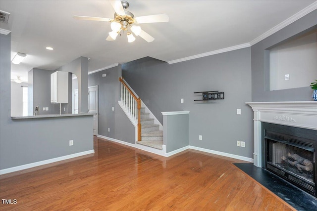 7616 Satinwing Ln, Raleigh, NC 27617 - unfurnished living room featuring ornamental molding, ceiling fan, wood finished floors, baseboards, and a fireplace with flush hearth