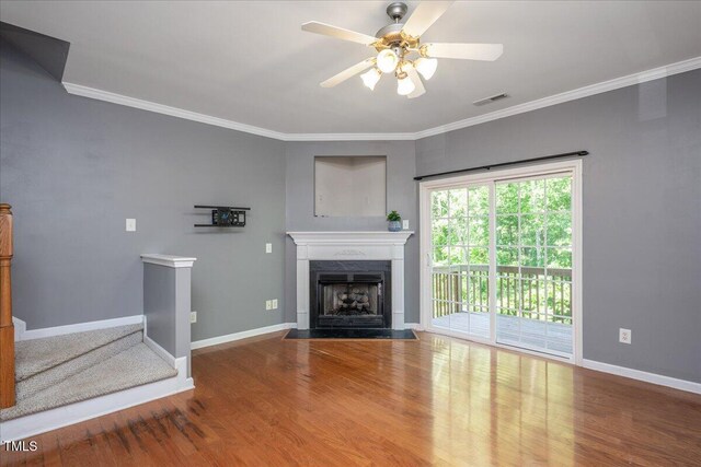 7616 Satinwing Ln, Raleigh, NC 27617 - unfurnished living room featuring wood finished floors, a ceiling fan, a fireplace with flush hearth, ornamental molding, and baseboards