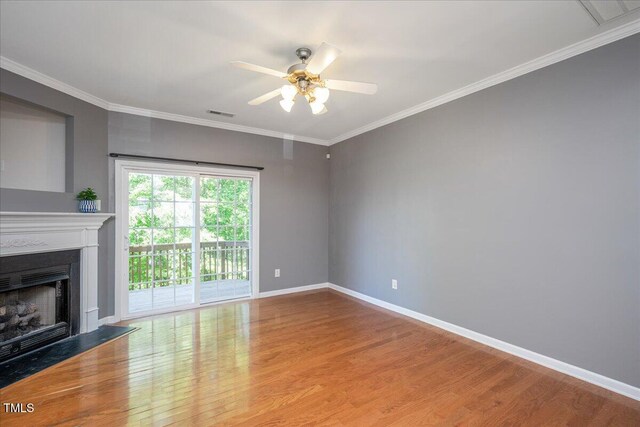 7616 Satinwing Ln, Raleigh, NC 27617 - unfurnished living room featuring wood finished floors, a fireplace, a ceiling fan, baseboards, and crown molding