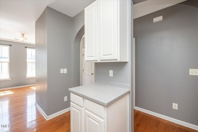 7616 Satinwing Ln, Raleigh, NC 27617 - kitchen with arched walkways, light wood-style floors, and baseboards