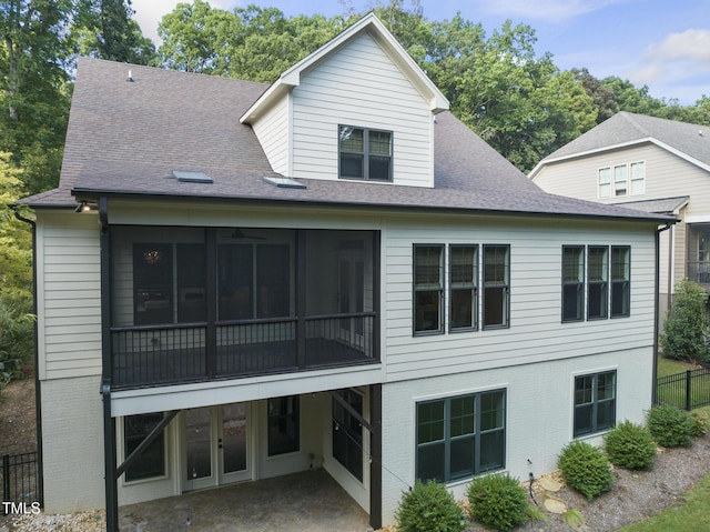 back of house with fence, a patio, roof with shingles, a sunroom, and brick siding