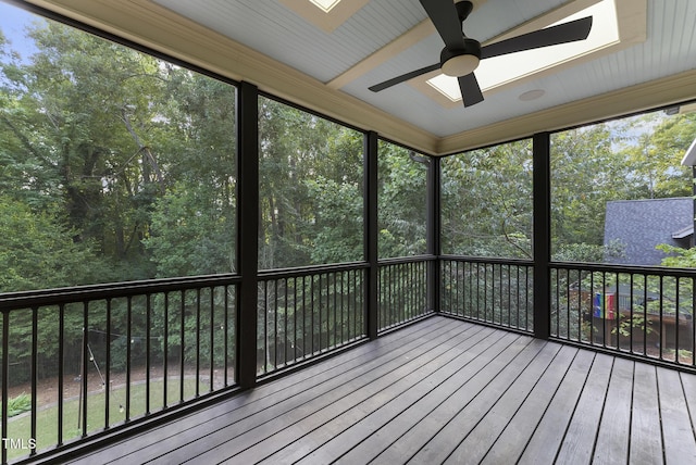 unfurnished sunroom featuring a ceiling fan and a skylight