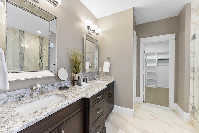 bathroom featuring a spacious closet, a sink, and a stall shower