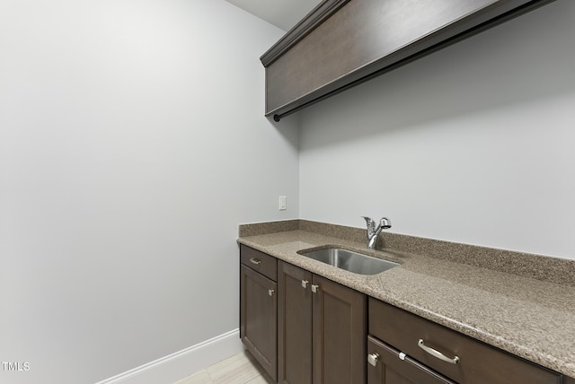 laundry room featuring baseboards and a sink